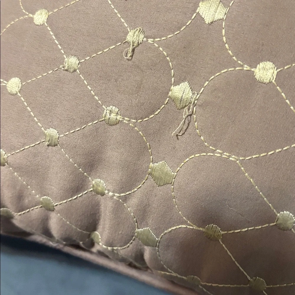 Mauve Quilted Throw Pillow square with some loose strings.